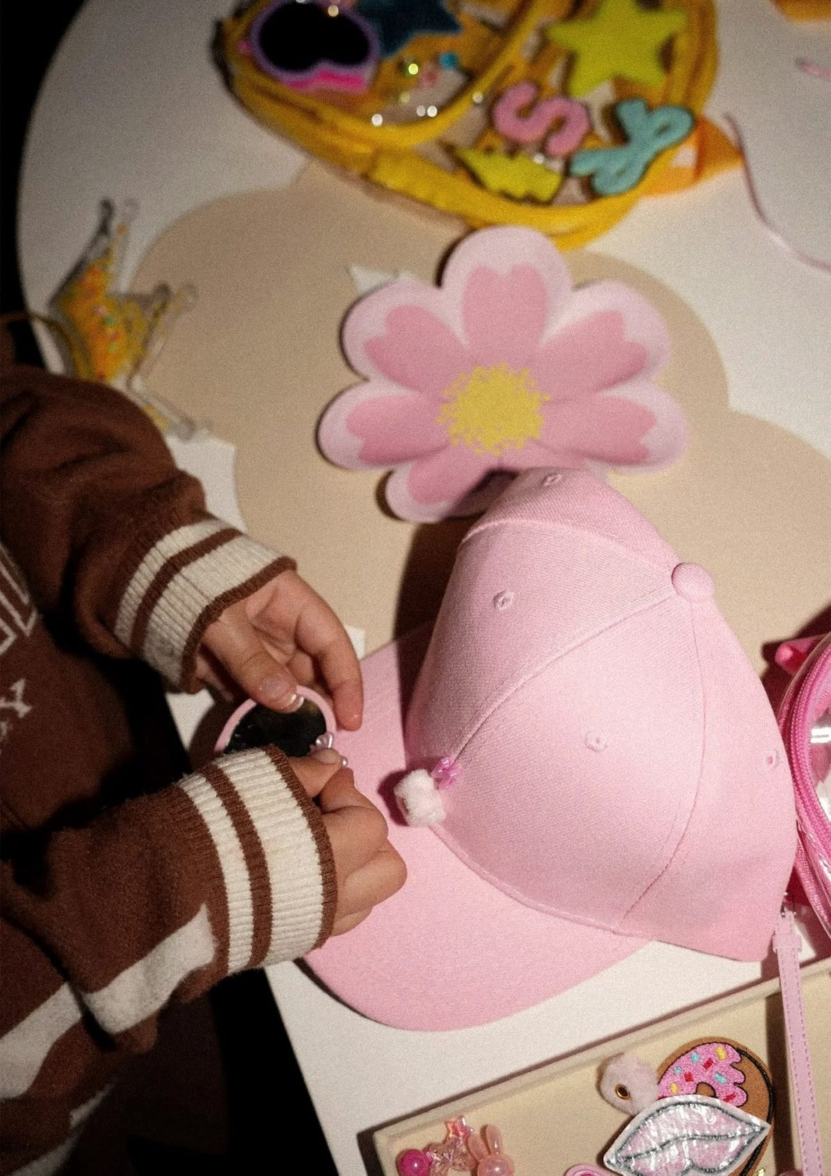 A child decorating a pink cap