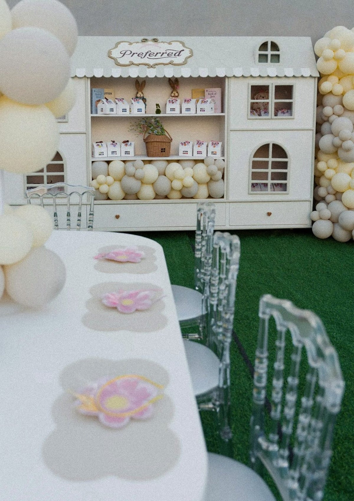 A Preferred dollhouse stand with balloons at a children's celebration