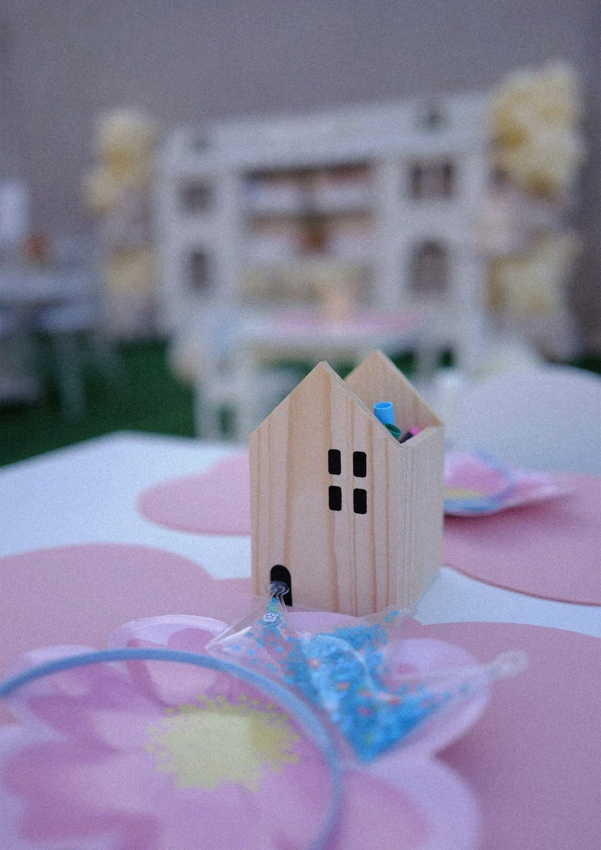 A little wooden house of pens on a party table